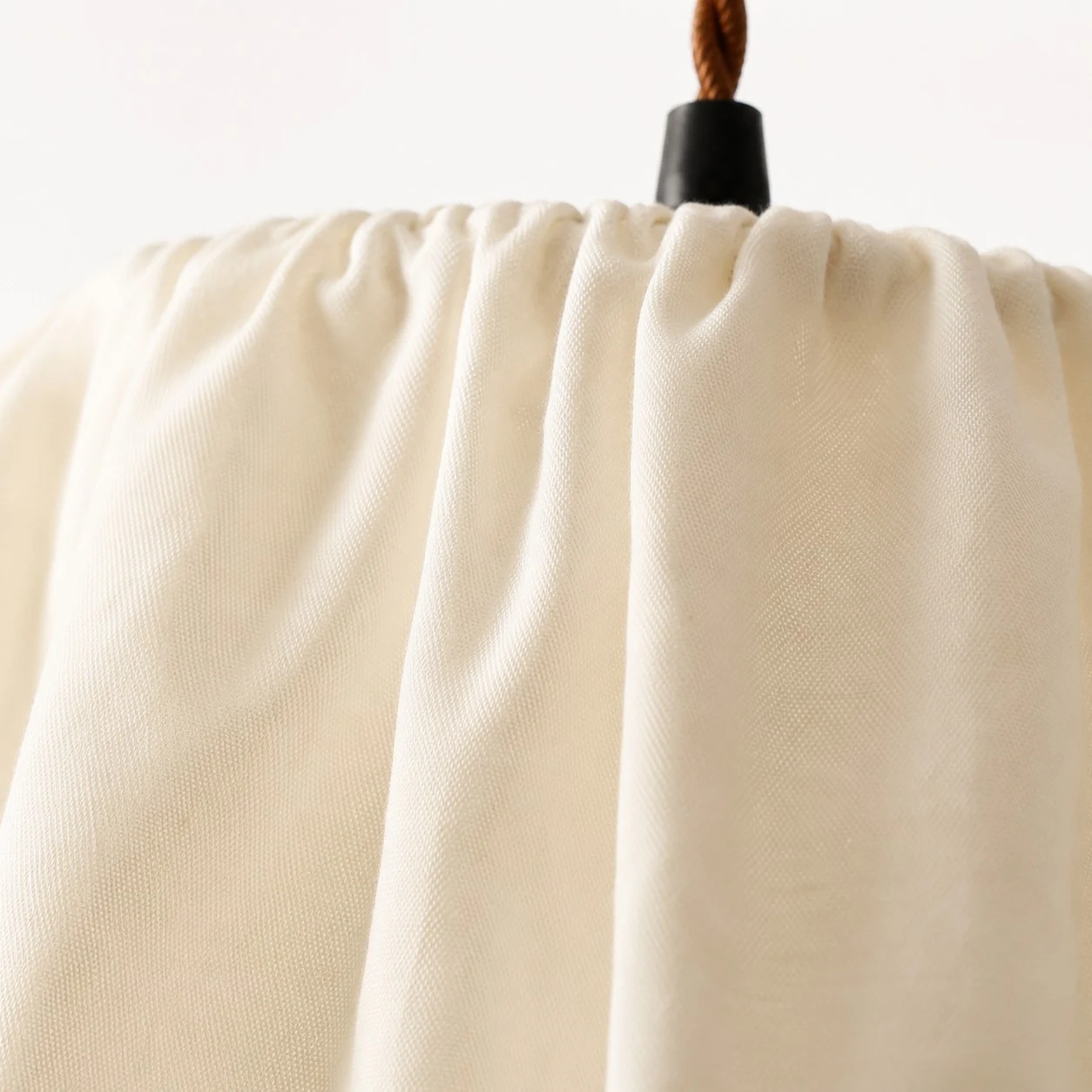 Close view of the gathered ivory fabric shade texture