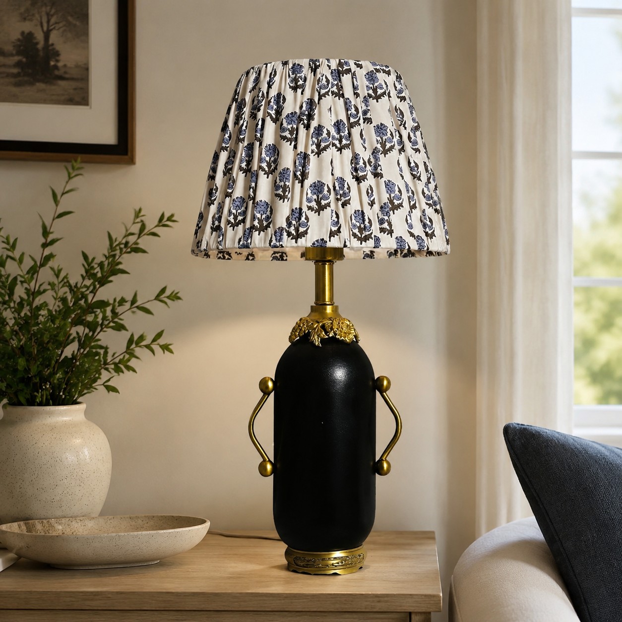 Matte black floral table lamp styled beside a green armchair
