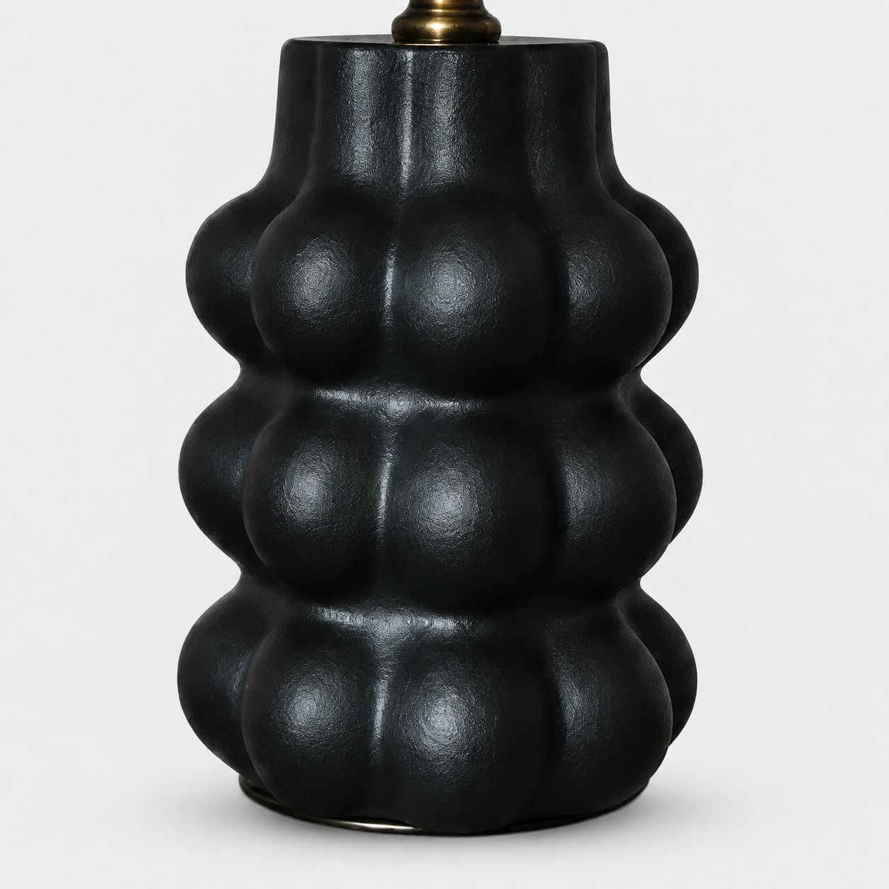 Sculpted matte black ceramic lamp base detail