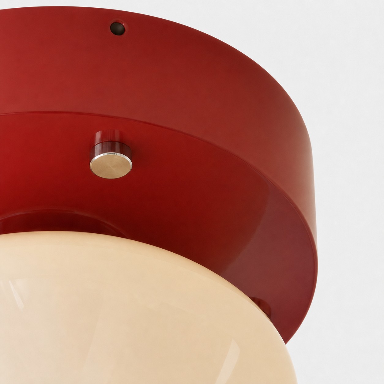 Angled close-up of red ceiling plate and brushed metal accent