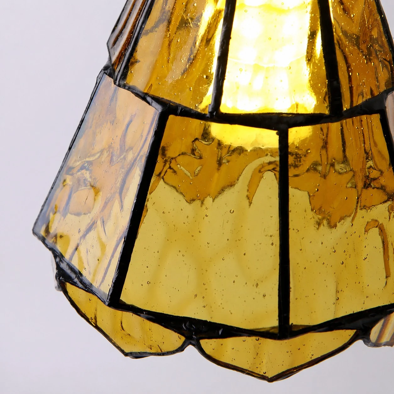 Närbild på bärnstensfärgad glasskärm med krusningar