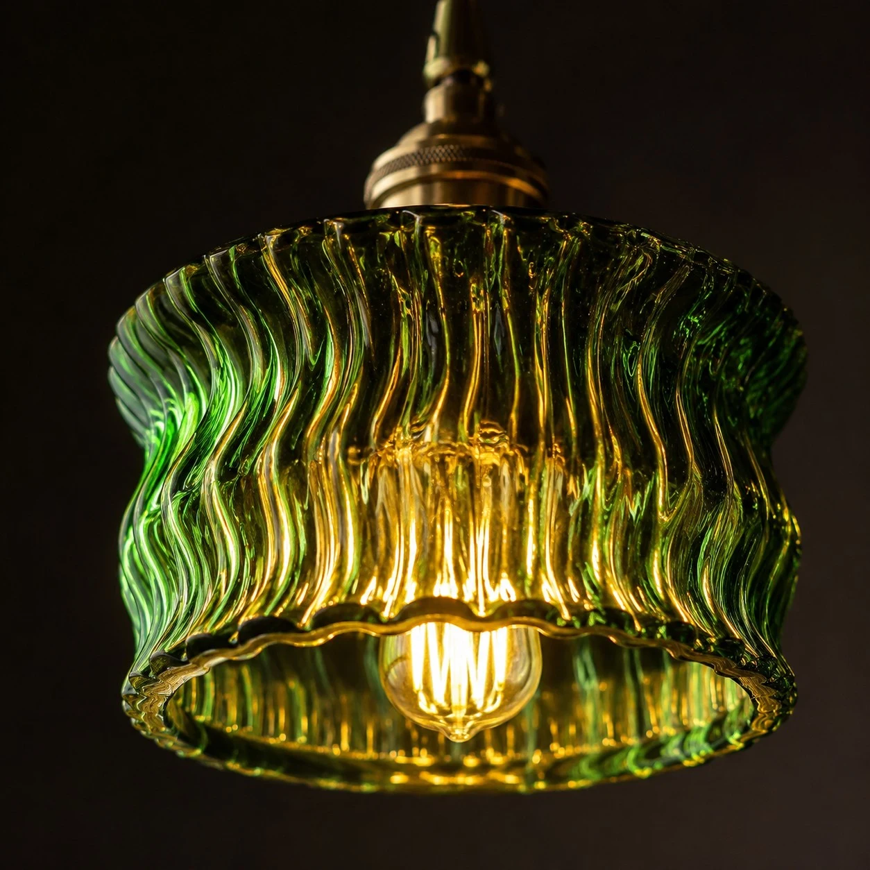 Warm light glowing through a zielony ripple glass pendant shade