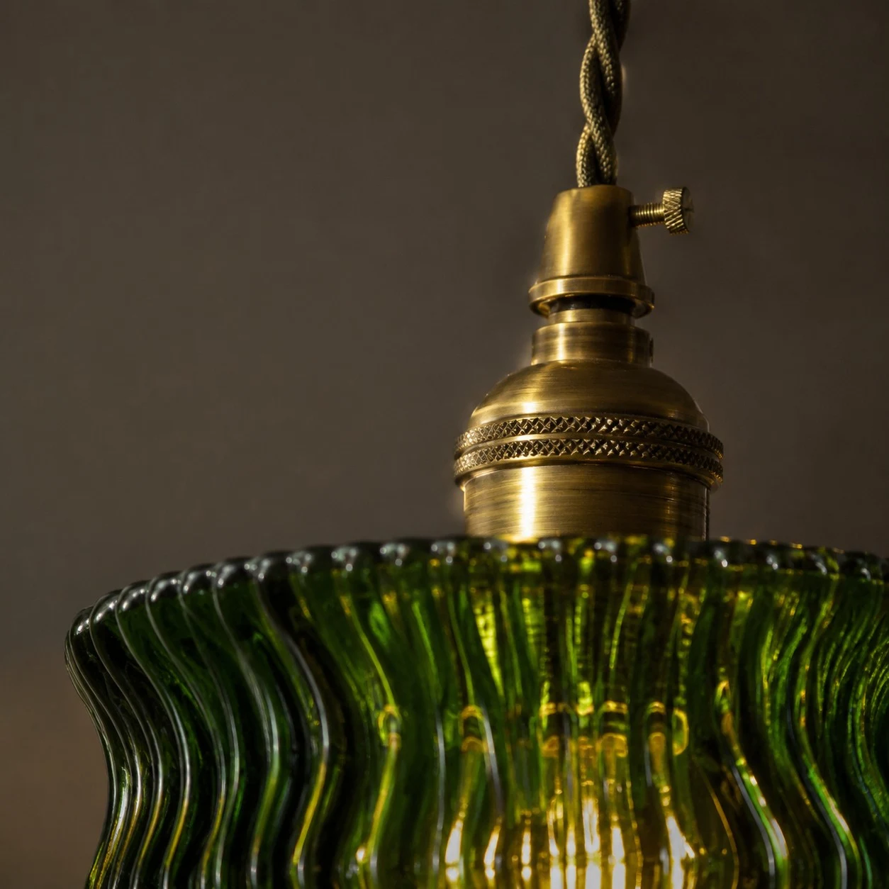 Detal mosiężnej glowicy above the green glass shade
